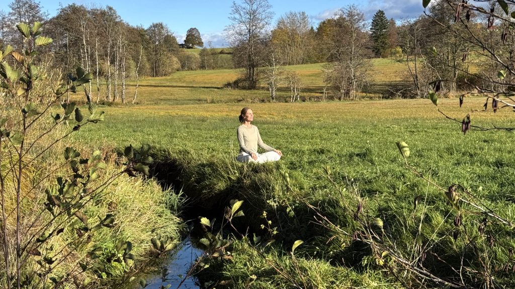Bärbel von YOGAMOUR meditiert am Bach