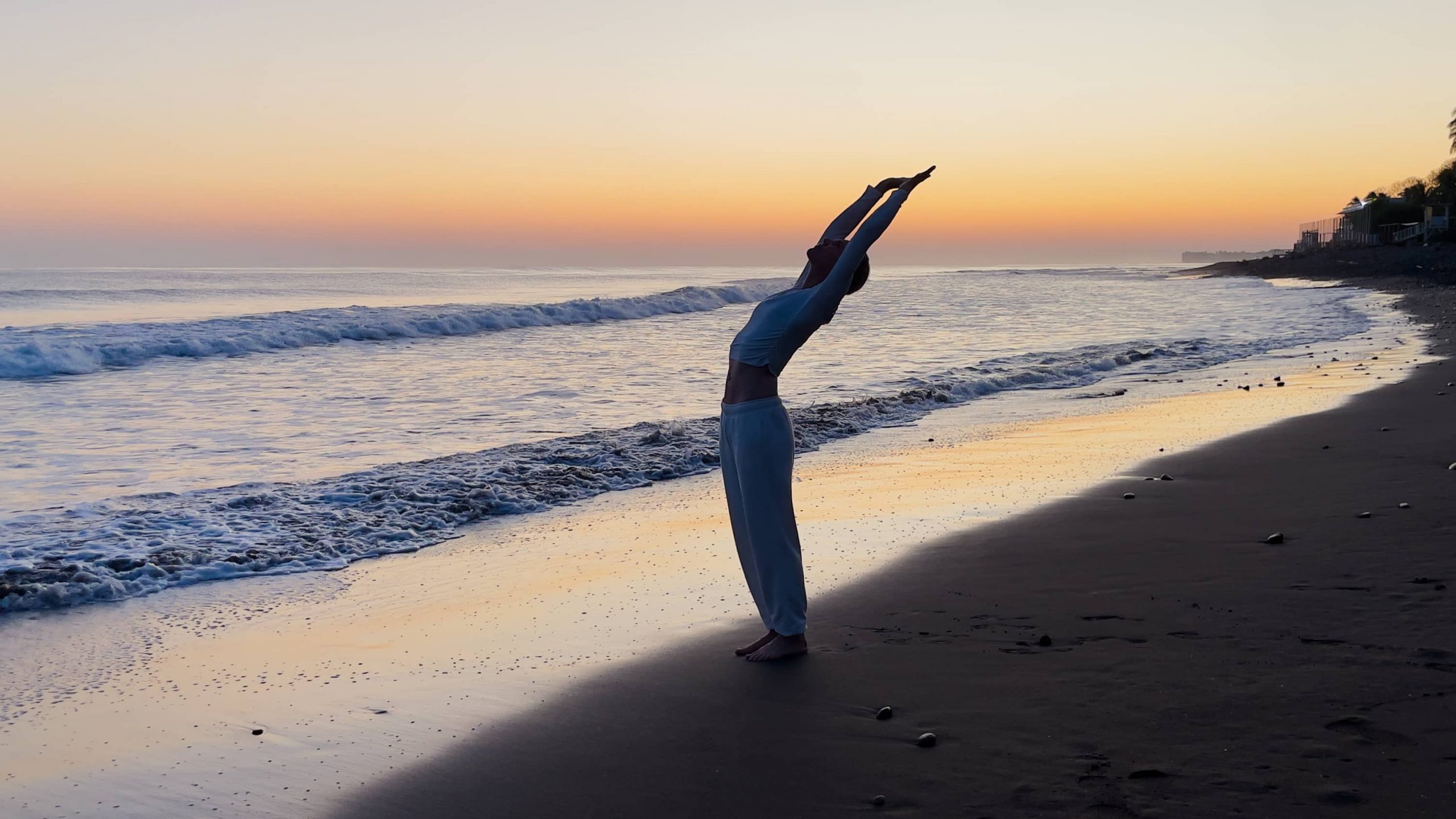 Bärbel bon YOGAMOUR übt Yoga am Strand bei Sonnenaufgang